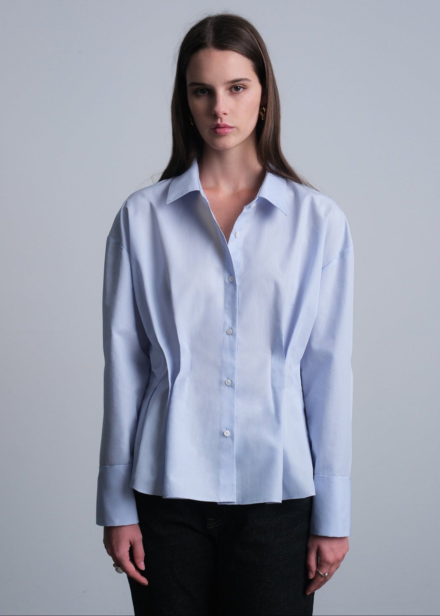 Woman wearing a light blue cotton button down shirt