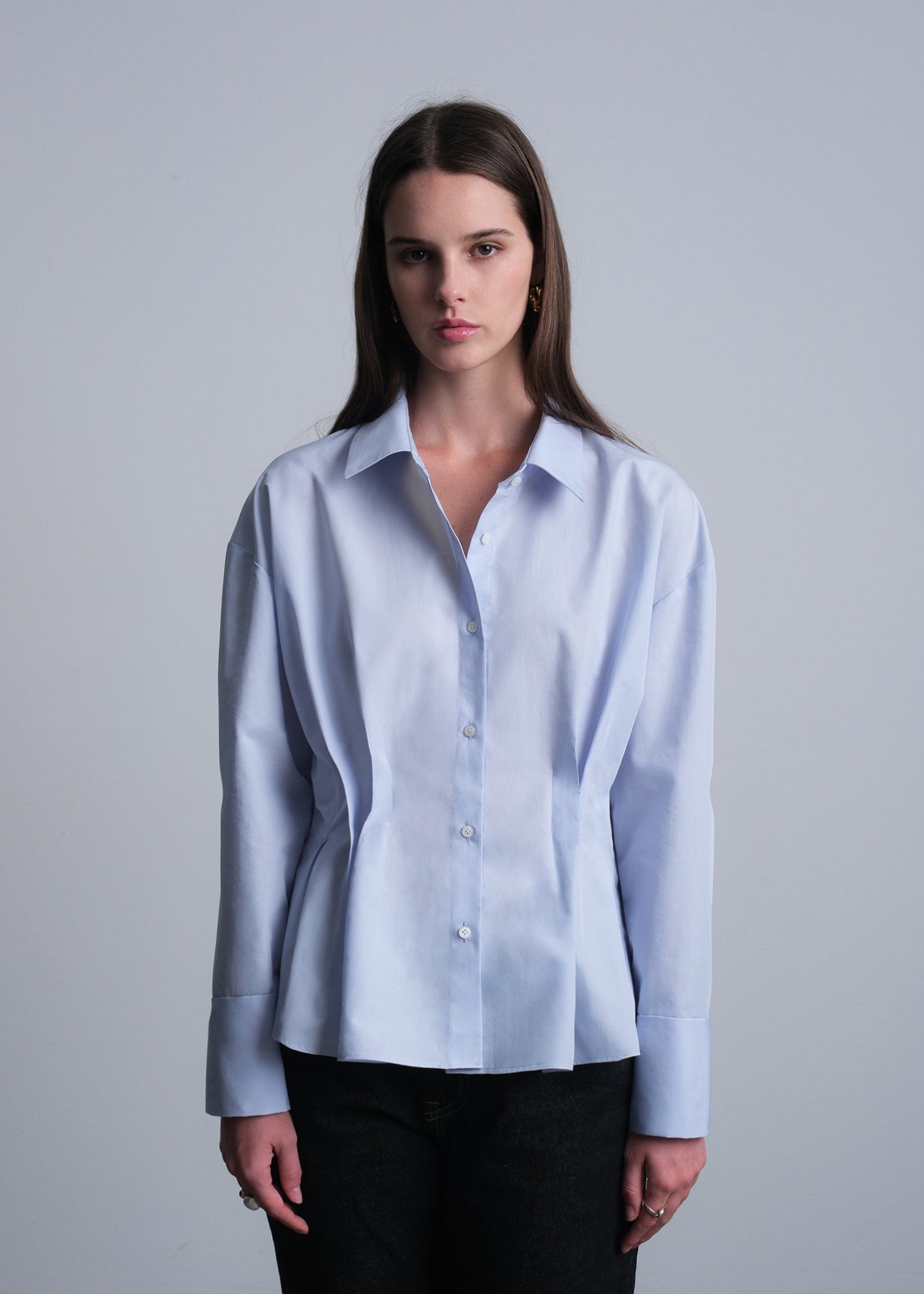 Woman wearing a light blue cotton button down shirt 