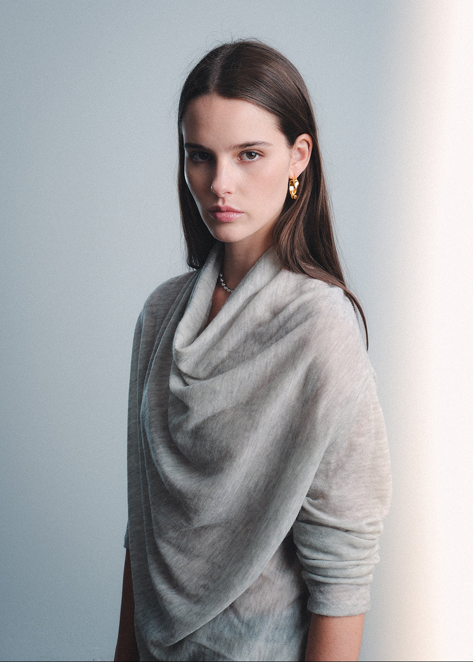 Woman wearing a light gray cashmere cowl neck sweater 