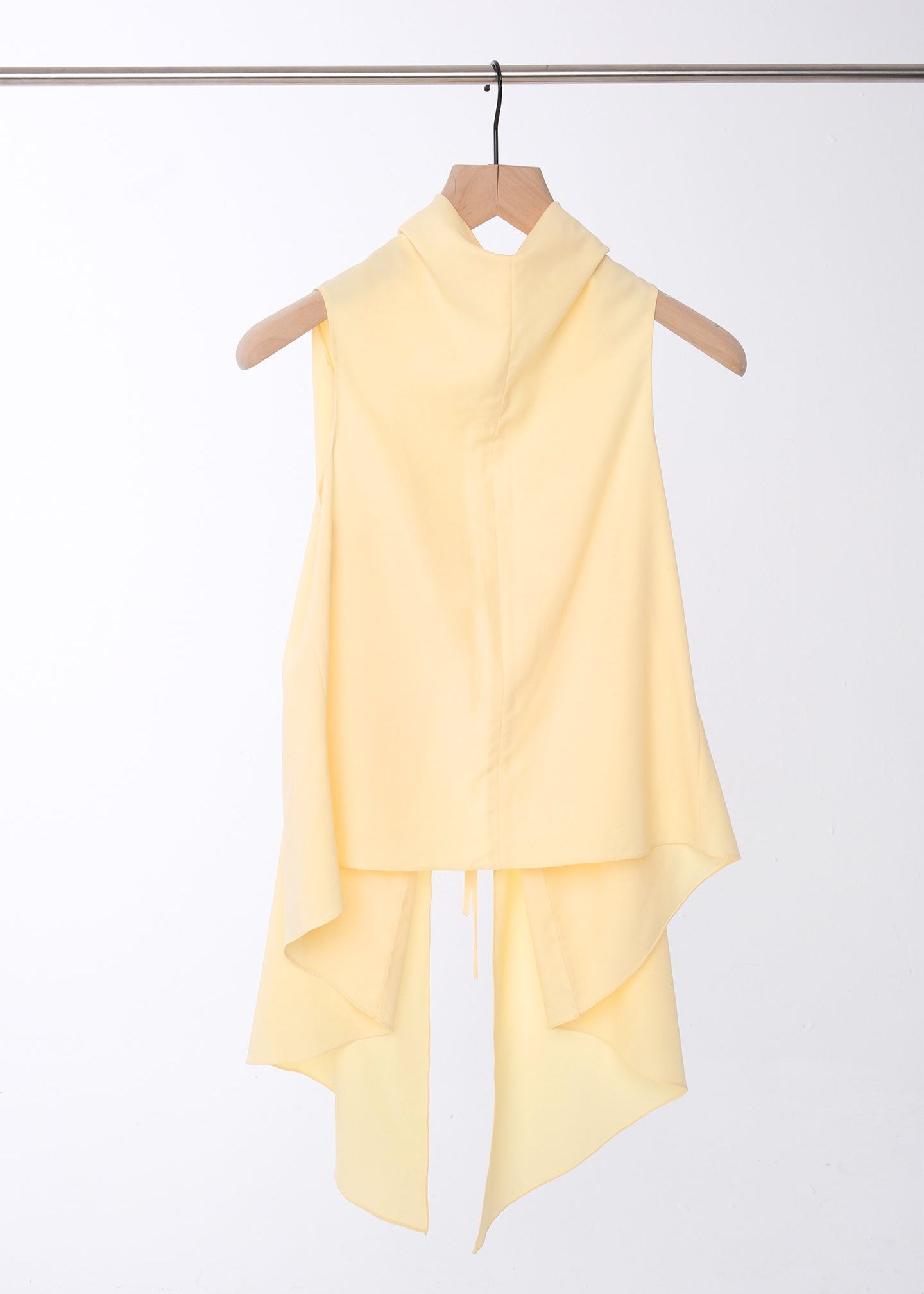 Sleeveless butter yellow cotton-rayon-poly blend top with an asymmetrical high-low hem and extended draped back panel tied at the side, featuring a clean crew neckline and soft, fluid silhouette.