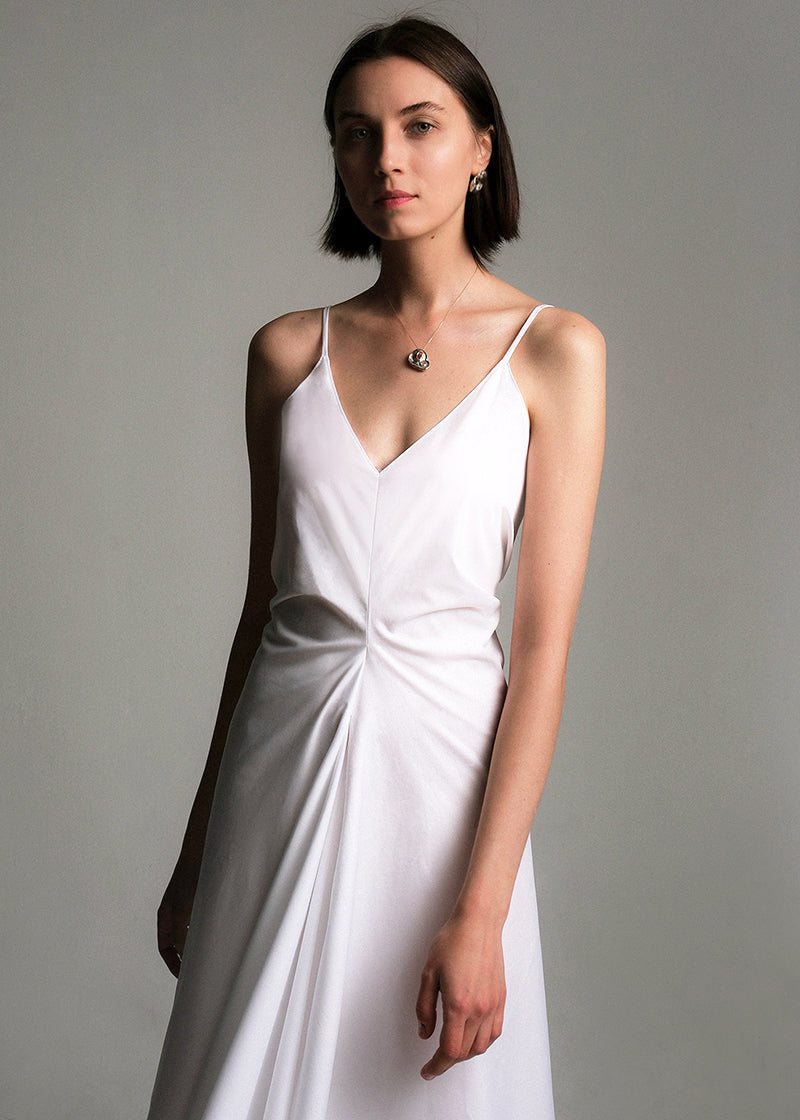 Sleeveless white midi dress made from cotton poplin, featuring a deep V-neckline, think spaghetti straps, a structured waist, and a softly flared A-line skirt.