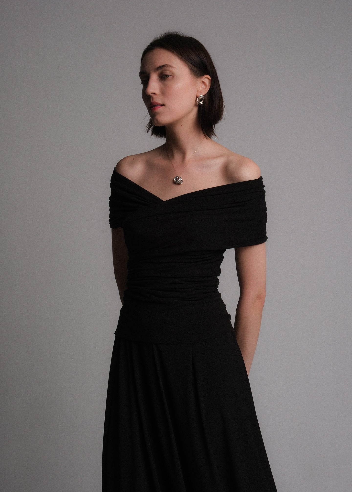 Women's off-the-shoulder black cotton-lyocell blend shirt featuring a draped, ruched design with a fitted silhouette.